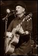 A person playing guitar and singing into a microphone

Description automatically generated with medium confidence