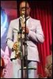 A person in a suit holding a saxophone

Description automatically generated with low confidence