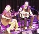 A person and person playing guitars on stage

Description automatically generated