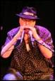 A person in a hat with microphones

Description automatically generated