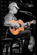 A person playing guitar and singing

Description automatically generated